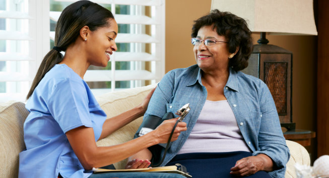 caregiver checking a senior woman