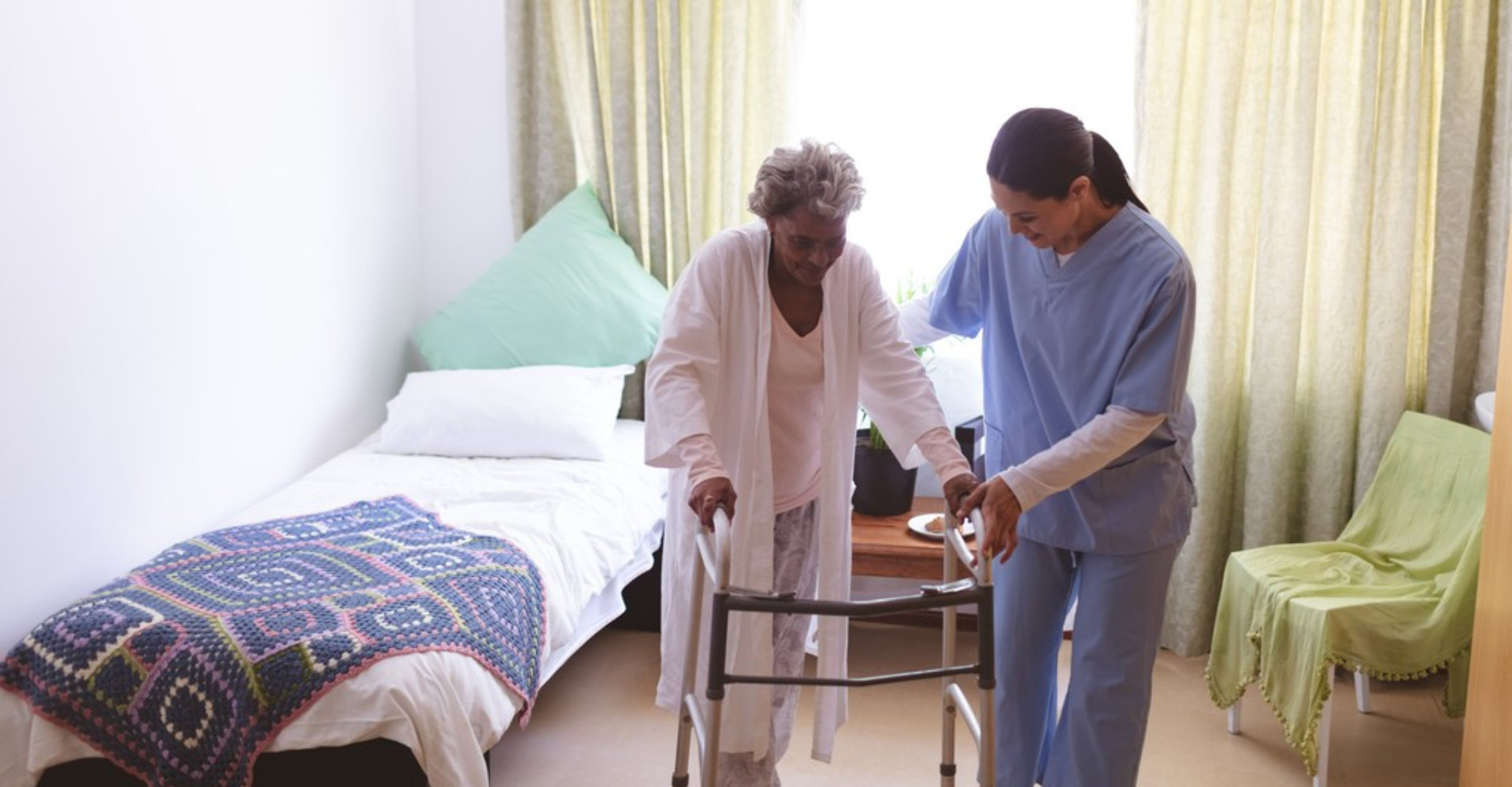 caregiver assisting senior woman to stand